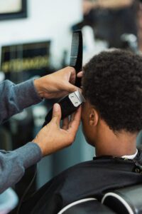 A man getting his hair cut by another person.