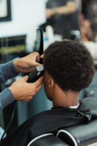 A person getting his hair cut by another person