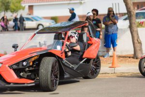 A person in a red and black car on street.