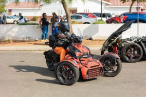 A motorcycle parked in the street with people standing around.