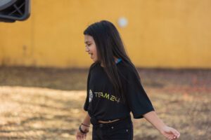 A girl in black shirt holding hands with another person.