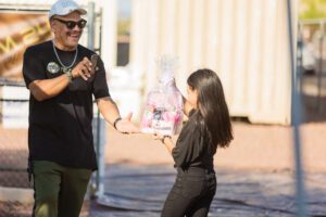 A man and woman are shaking hands outside.