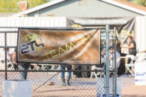 A banner hanging on the side of a fence.