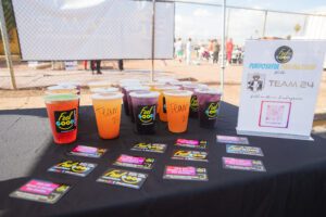 A table with several cups of juice on it.