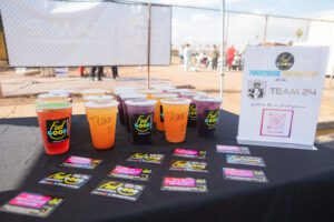 A table with several cups of juice and tickets.