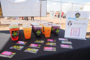 A table with several cups of juice on it.