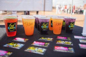 A table with several cups of juice and cards.