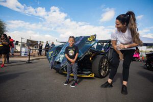 A woman and child standing next to a car.