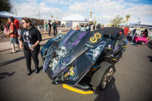 A car with skulls painted on it is parked.