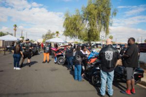 A group of people standing around parked motorcycles.