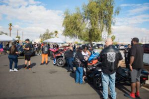 A group of people standing around parked motorcycles.