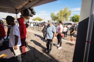 A group of people standing around an outdoor tent.