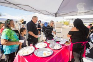 A group of people standing around a table with plates.