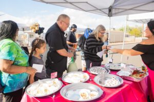 A group of people standing around a table with plates.