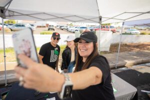 A woman taking a selfie with two other people.