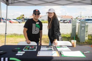 Two people standing next to a table with papers on it.