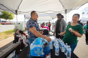 A group of people standing around water bottles.