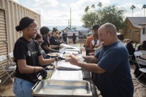 A group of people sitting at tables with food.