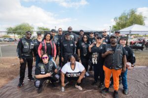 A group of people in black jackets and orange pants.