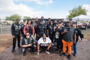 A group of people in black jackets and orange pants.