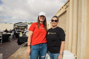 Two women standing next to each other in front of a building.