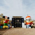 A couple of inflatable characters are near a sign