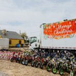 A truck with many bicycles parked in front of it.