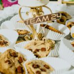 A table topped with lots of cookies and cups.