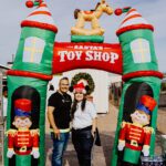 A man and woman standing in front of an inflatable toy shop.