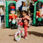 A little girl riding on the back of a bike.