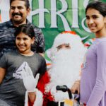 A family posing with santa clause at an event.