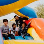 A group of kids sitting on top of an inflatable slide.