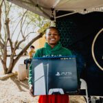 A young boy holding a large black box.