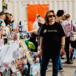 A woman standing in front of a table full of toys.