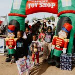 A group of children standing in front of toy shop.