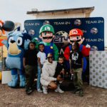 A group of people posing for a picture with mario and luigi.