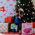 Two children standing in front of a christmas tree.