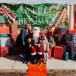 A woman and two children posing with santa claus.