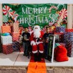 A group of kids standing around santa clause.