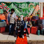 A group of people standing around with christmas presents.