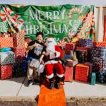 A man and child posing for a picture with santa claus.