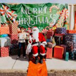 A person in santa claus costume sitting on the ground.