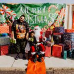 A man and child posing with santa claus.