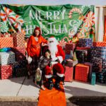 A woman and child posing with santa claus.