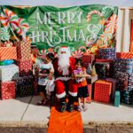 A group of kids sitting around santa clause.