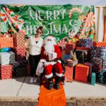 A man in santa suit sitting on top of a box.