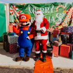 Two people dressed as mario and santa claus