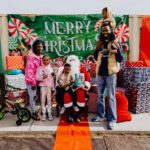 A group of people posing for a picture with santa claus.