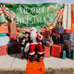 A man sitting in front of many presents.