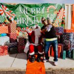 A man and woman posing for a picture with santa.